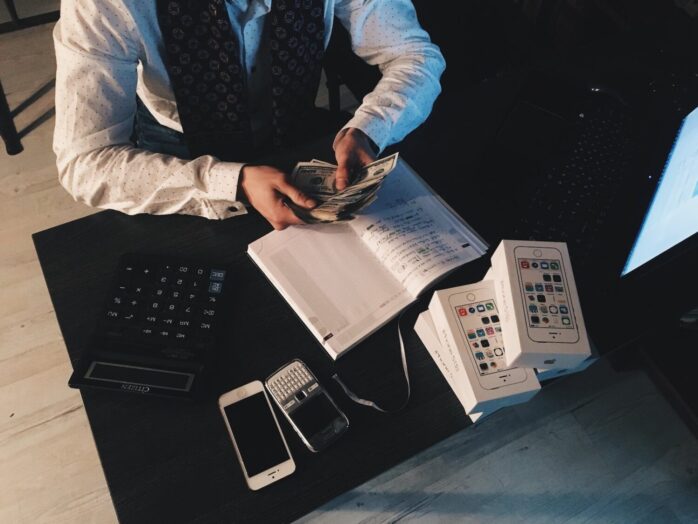 A man dressed in a suit counting money. Depiction of the benefits of languages interpretor