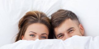 Couple Under Bed Sheets. Guide on How to Have a Better Sex.