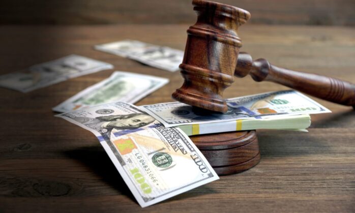 Bundle Of Money, Judges Gavel And Soundboard On Wooden Table