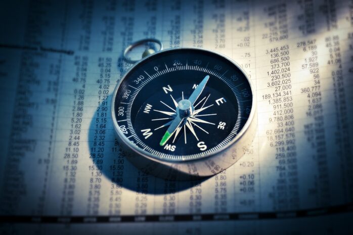 Compass on a sheet detailing stock information
