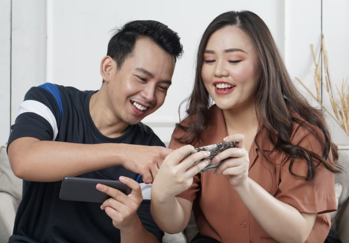 Image of excited young man and woman playing together and competing in video games on smartphones